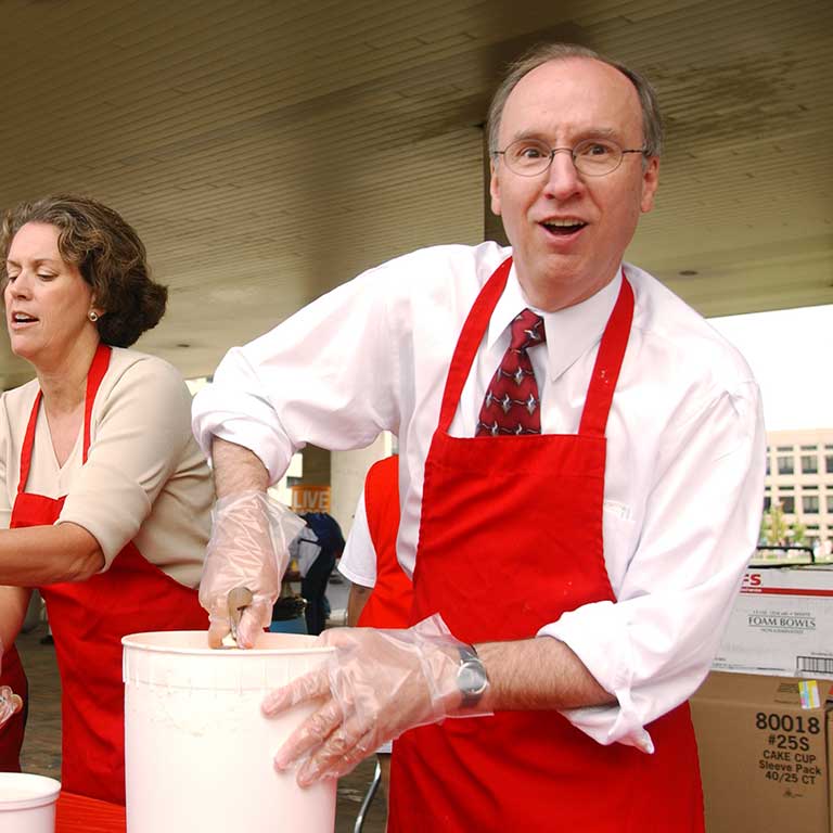 Former IUPUI Chancellor Charles Bantz scoops ice cream at his first Weeks of Welcome Ice Cream Social.