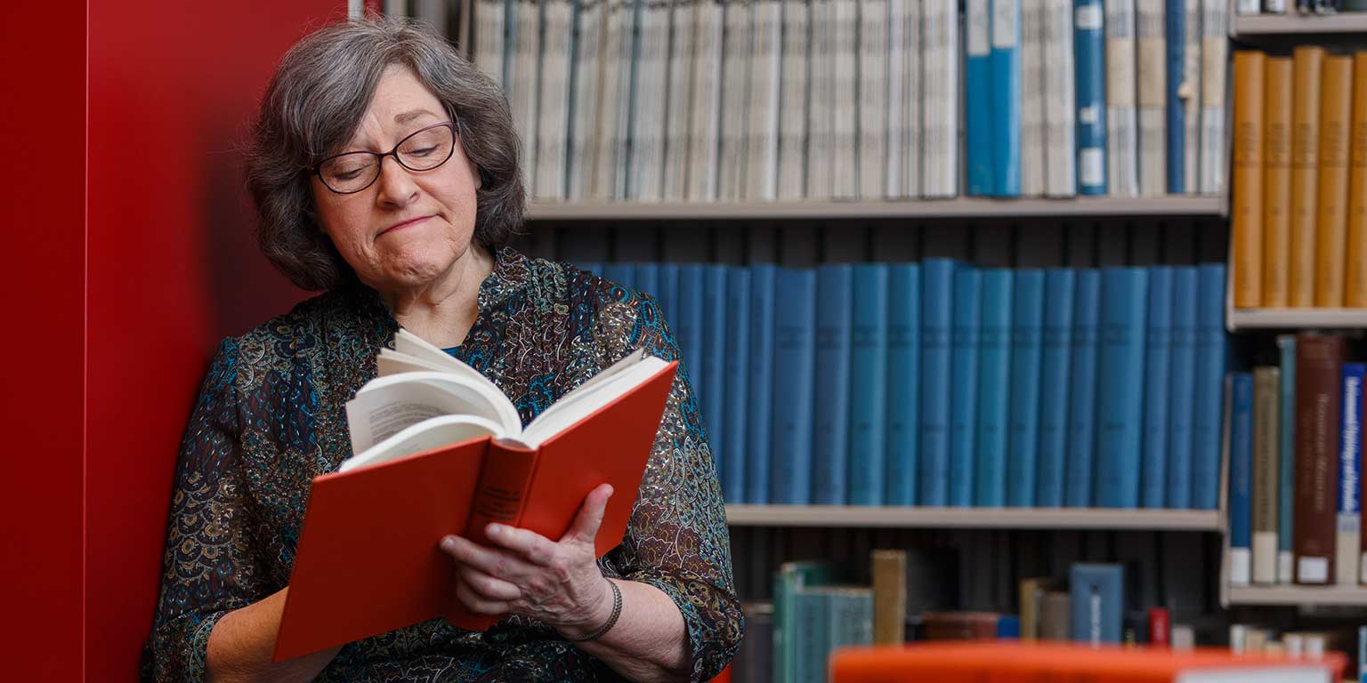 Claudia Dille thumbs through a book in University Library.