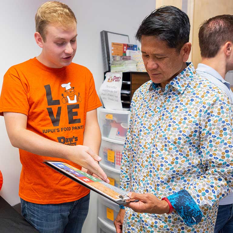 Merlin Gonzales chats with Paw's Pantry student chair Michael Stottlemyer.