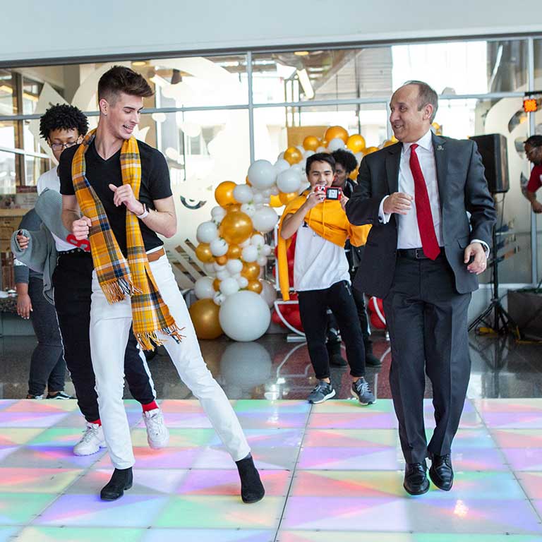 Chancellor Nasser Paydar dances with students at IUPUI's 50th Anniversary Birthday Bash in 2019.