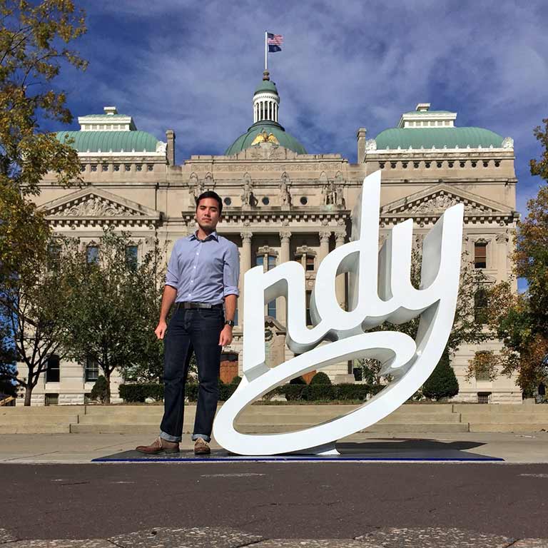 Andre Zhang Sonera stands as the 'I' of 'Indy' in front of the Indiana Statehouse. 