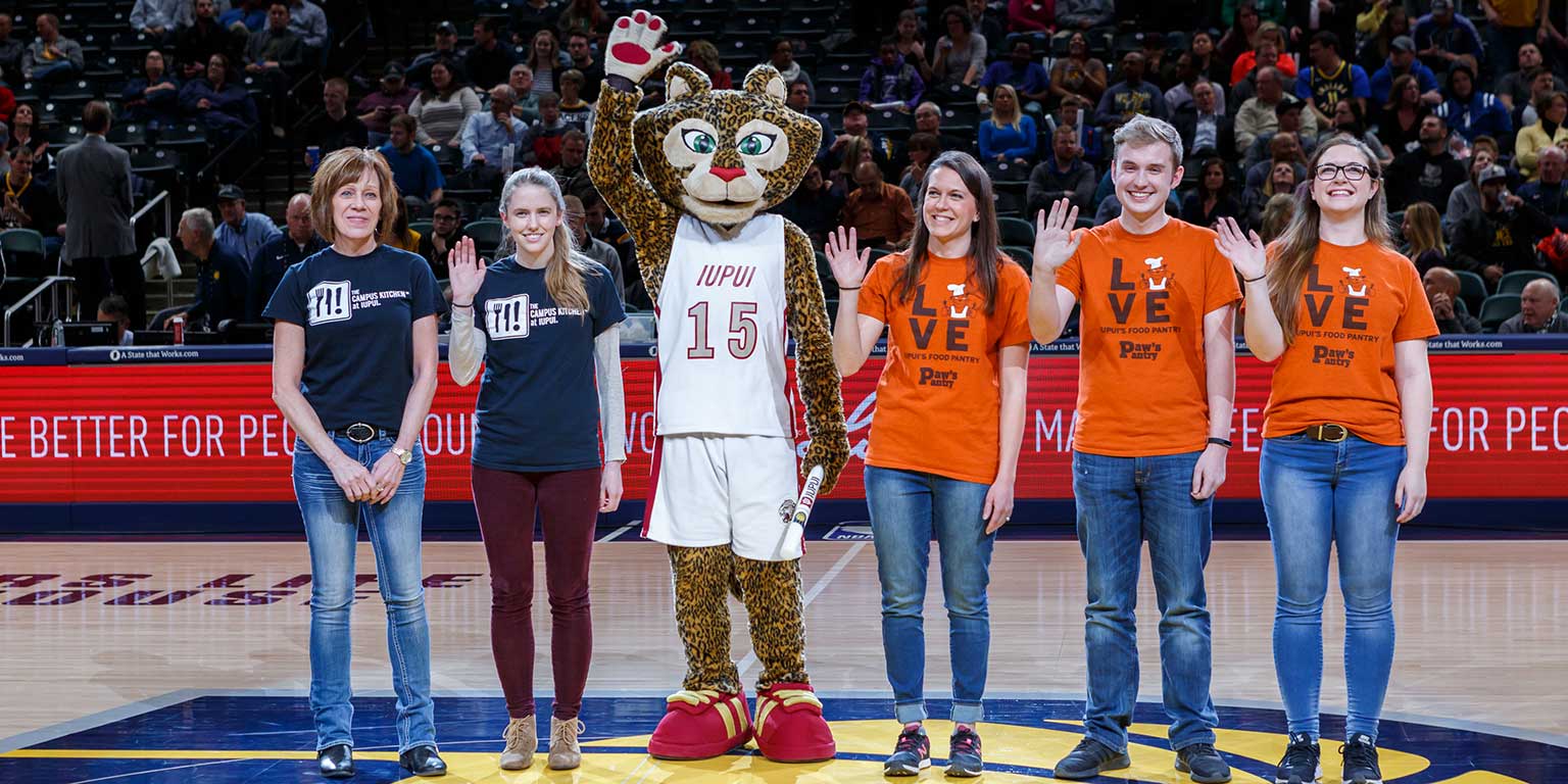 Michael Stottlemyer waves on court at a Pacer's game during IUPUI night.