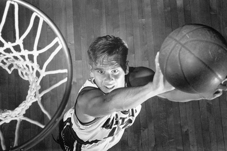 A Metros basketball player is moments away from making a slam dunk. Black and white photo.