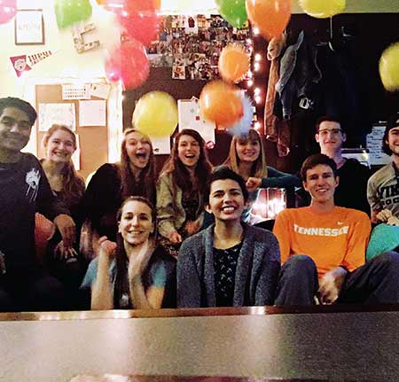 A group of students smile in a classroom